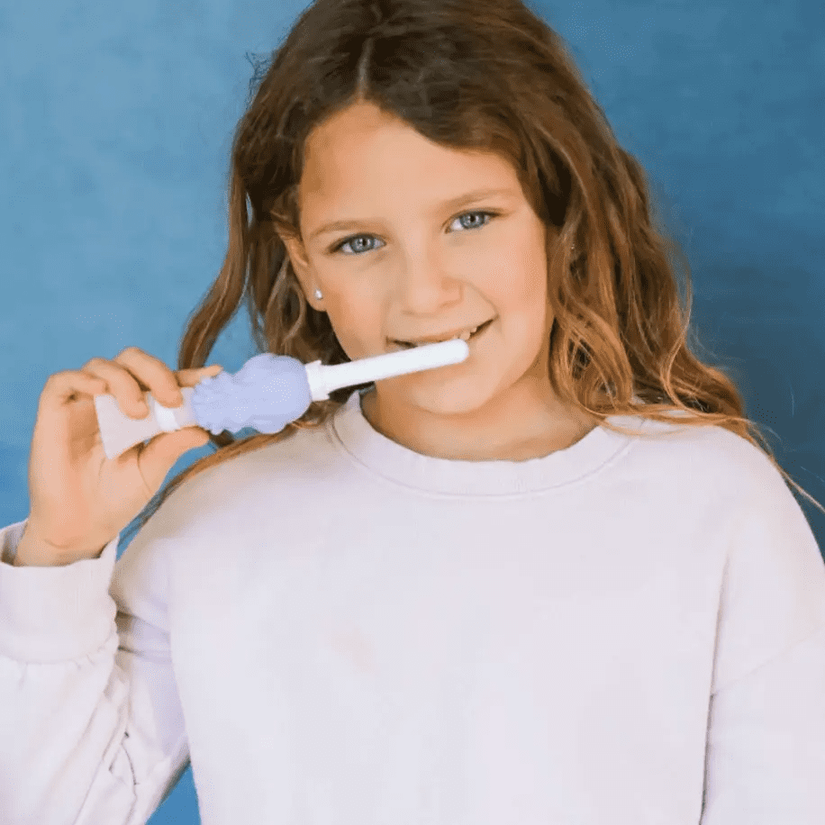 Young girl brushing her teeth using Princess Pearly Whites toothbrush
