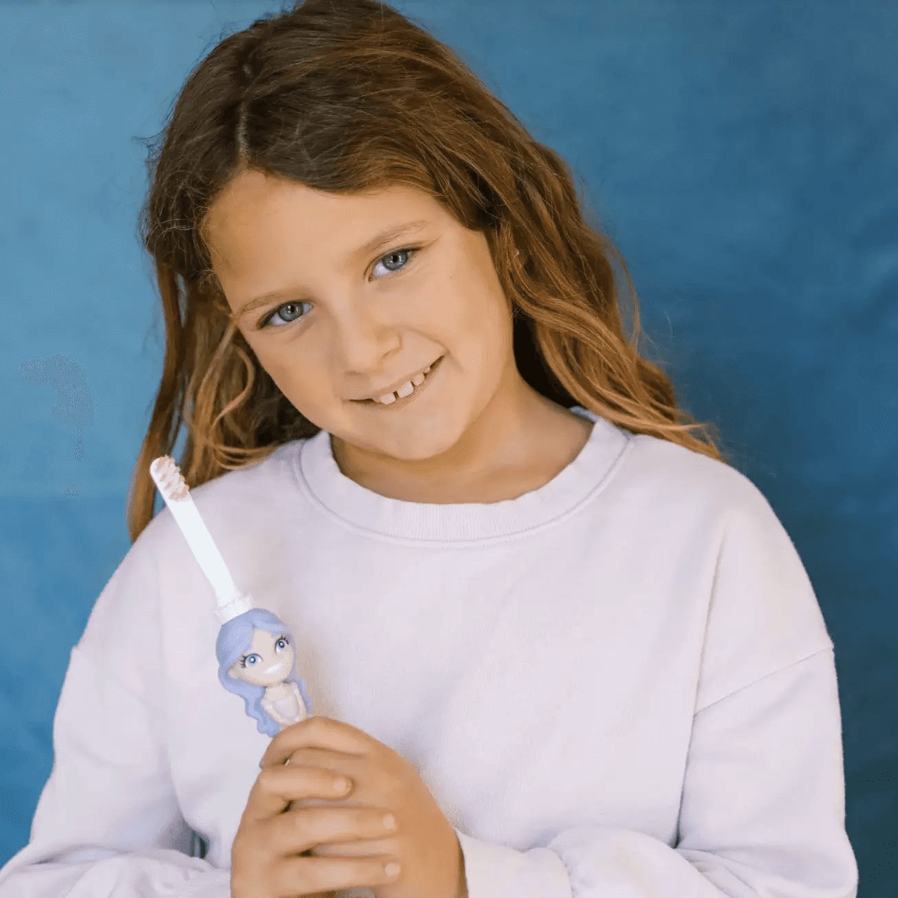 Young girl holding Princess Pearly Whites toothbrush