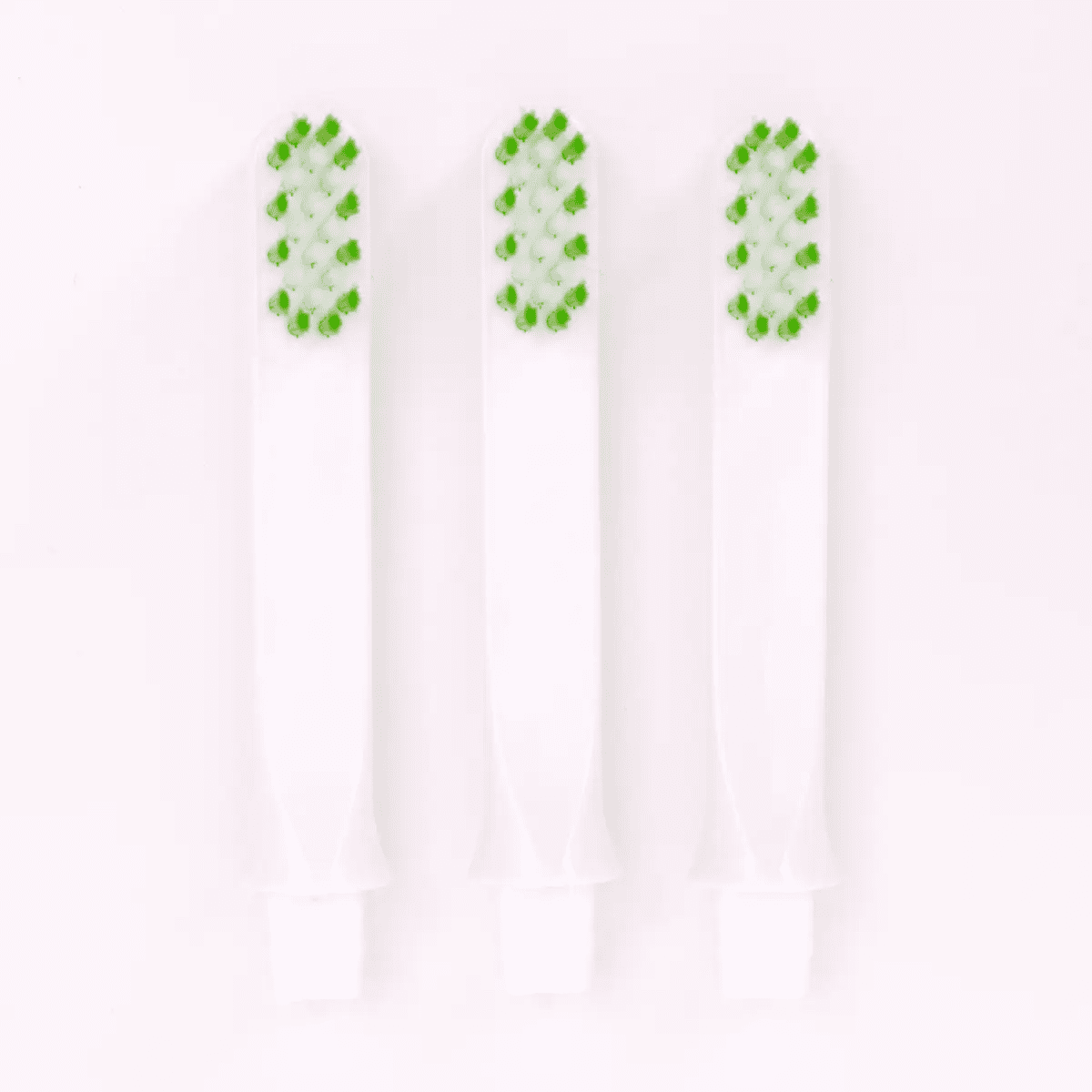 Three replacement toothbrushes with green and white bristles